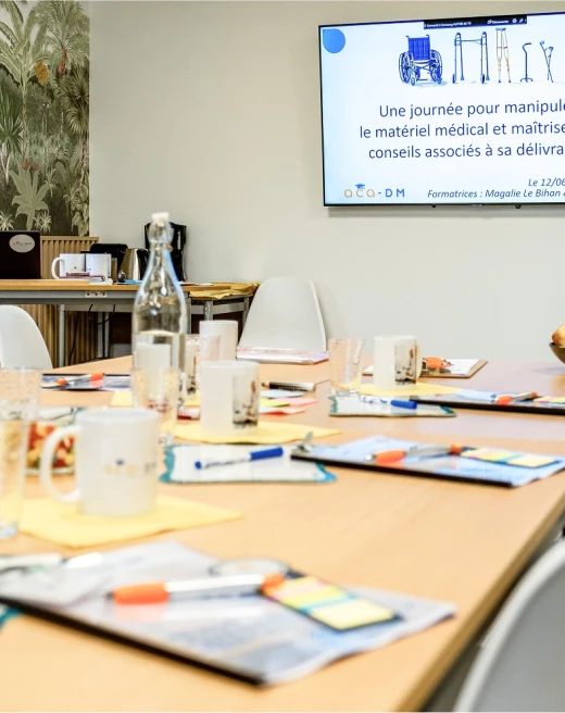 Une salle avec sur un écran le texte « une journée pour manipuler le matériel médical... »